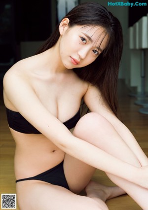 A woman in a pink bodysuit posing for a picture.