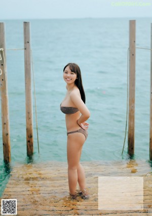 A woman in a black bikini posing for a magazine.