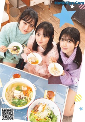 A group of young women eating food in a kitchen.