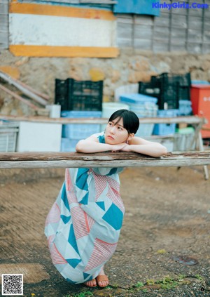 A woman standing in front of a blue building.