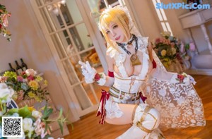 A woman with pink hair sitting on a white table.