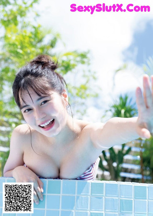 A woman in a bathing suit waving at the camera.