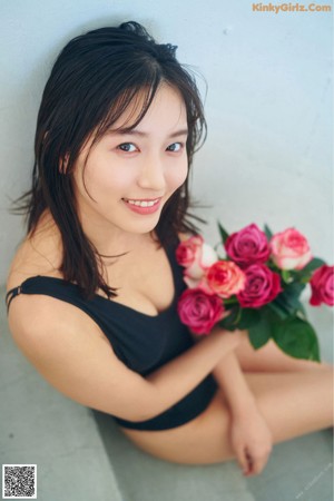 A woman laying on a table with a bunch of roses.