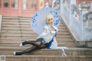 A woman in a white dress holding an umbrella.