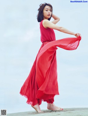 A woman in a red dress posing for a picture.