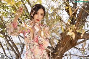 a woman in a white bra top and floral skirt posing for the camera