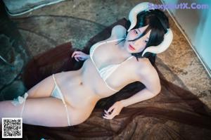 A woman in a white lingerie with horns on her head.