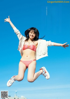 A woman in a pink bikini posing for a magazine.