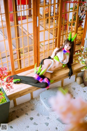 A woman in a bikini and bunny ears posing for a picture.