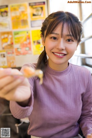 A woman cutting up a salad with a knife and fork.