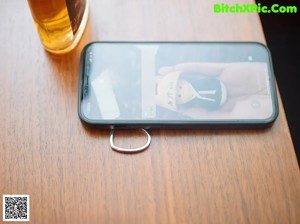 A woman sitting at a table with a cell phone in her hand.