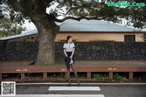 A woman sitting on a bench wearing black stockings.