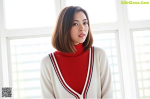 A woman in a red and white lingerie posing for a picture.