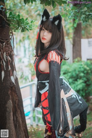 A woman in a black and red kimono with a cat ears headband.