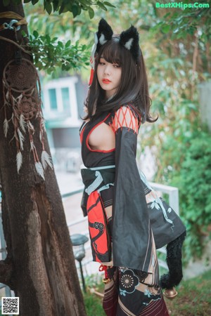 A woman in a kimono sitting on a stool.