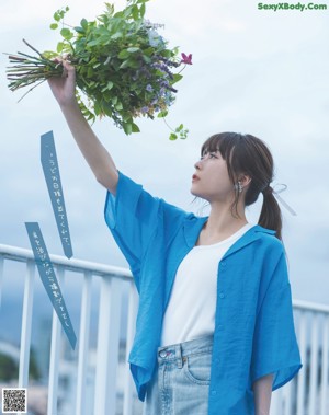 A woman in a white dress standing on a balcony.