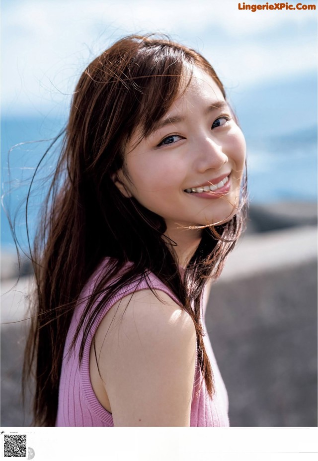 A young woman with long brown hair smiling at the camera.