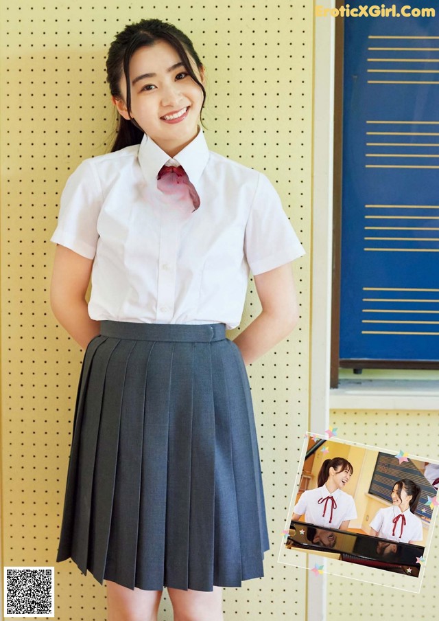 A woman in a school uniform posing for a picture.