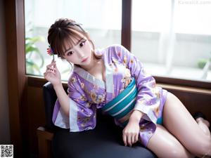 A woman in a blue kimono posing for a picture.