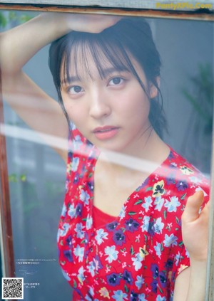 A woman in a white shirt is looking at the camera.