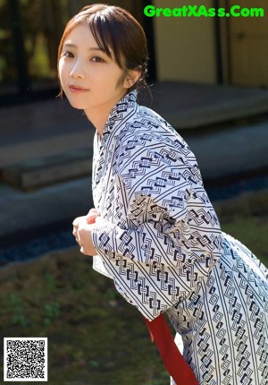 A woman in a red sweater posing for a picture.